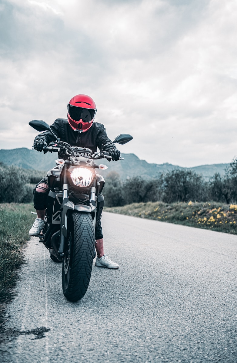 a man riding a motorcycle down a curvy road, motorcycle insurance